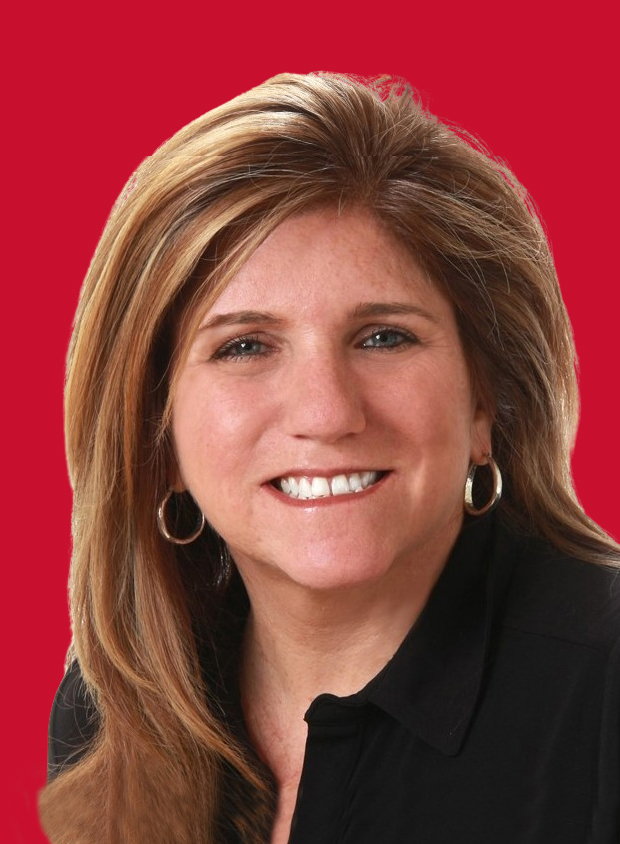 Portrait of Carrie Rinker with shoulder-length blonde hair, wearing a black blouse and silver hoop earrings, smiling against a solid red background.